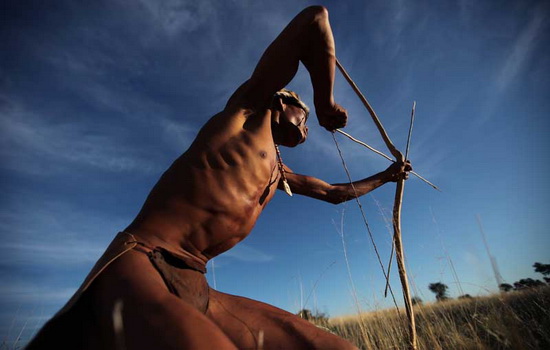 UPINGTON, SOUTH AFRICA - OCTOBER 16: A bushman from the Khomani San community strikes a traditional pose in the Southern Kalahari desert on October 16, 2009 in the Kalahari, South Africa. One of the largest studies of African genetics by an international team from the University of Pennsylvania, published in April 2009, revealed that the San of Southern Africa are the most genetically diverse on earth, and that the San homeland could be the spot where modern humanity began. The Central Kalahari Game reserve is one of South Africa's largest nature reserves, bordering Botswana and Namibia, and is home to the San, or Bushmen, the last indigenous people of South Africa. Many of the San groups were forcibly removed from their ancestral land in the Kalahari Gemsbok National Park in 2002 by neighbouring Botswana's government to make way for Diamond Mining, leaving their traditional nomadic hunter-gatherer lifestyle under threat. In 2006 the Bushmen won an historic ruling against the government allowing them to return to their ancestral land. With no direct access to water and the lure of modern trappings many did not return, choosing to stay in the settlements surrounding the park. (Photo by Dan Kitwood/Getty Images)